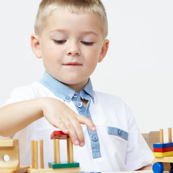 boy stacking blocks in therapy
