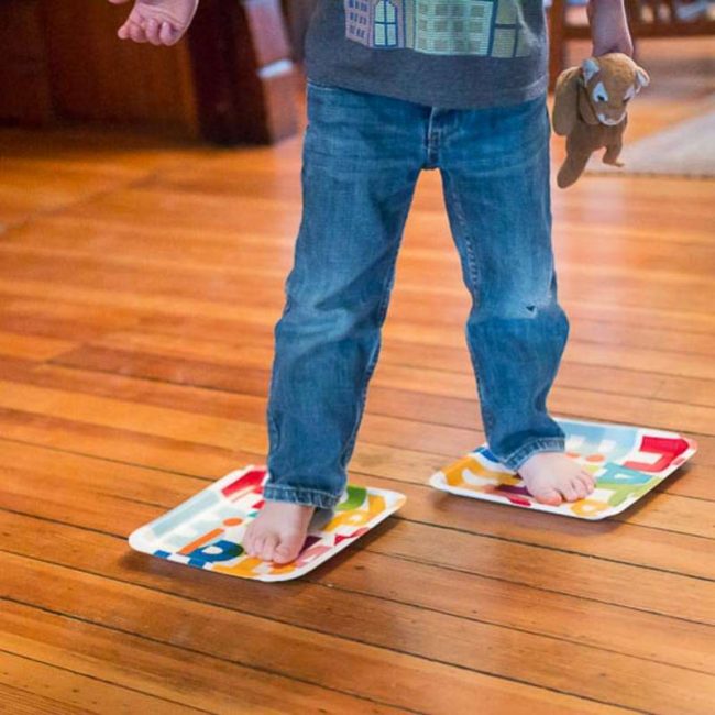 Paper plate ice skating on floor